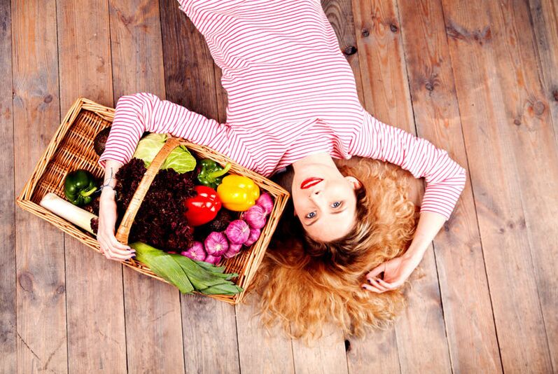 Fille avec un panier de légumes.